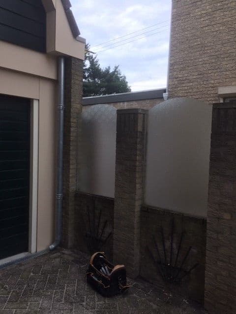 Tussenschotten van glas in tuin geplaatst