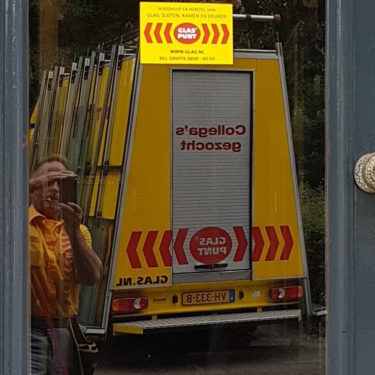 Glaspunt bus en monteur weerspiegeling in gelaagd glas
