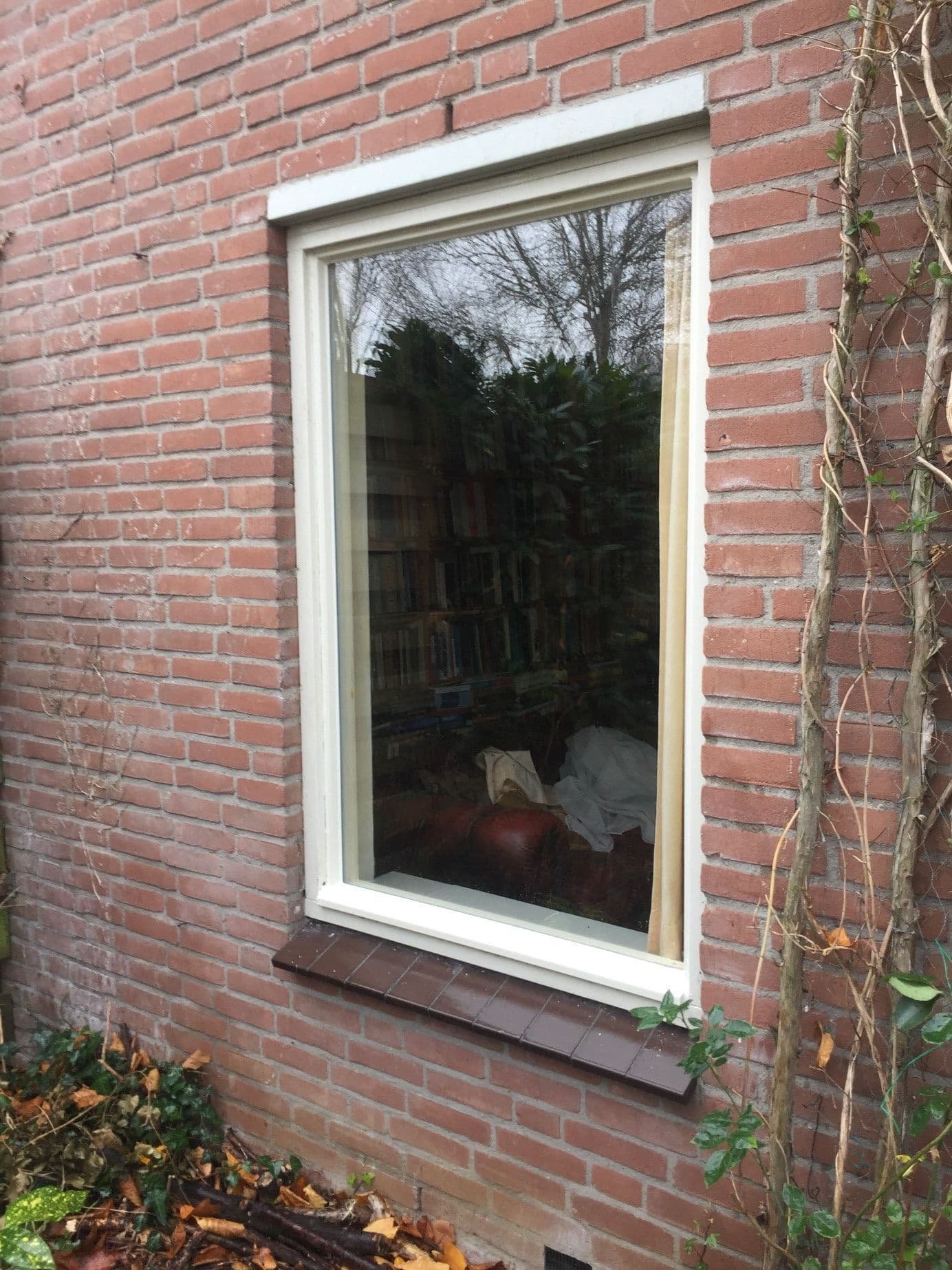 Dubbel glas ruit met lekslag en condens tussen de glaslagen bij een woning in Zeist.