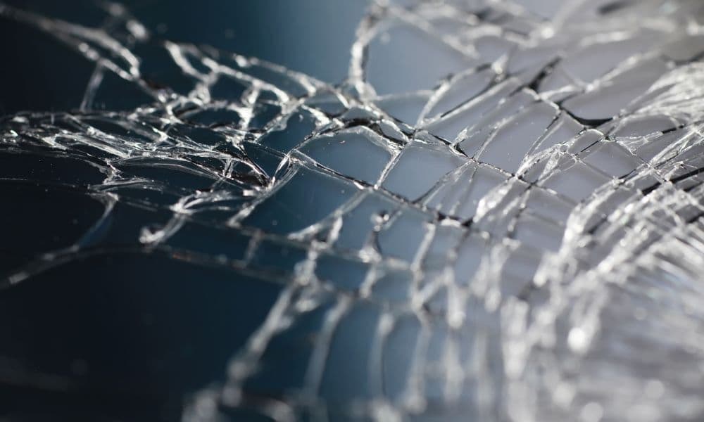 Gebroken gehard gelaagd glas met kleine fragmenten die bij elkaar blijven door folie