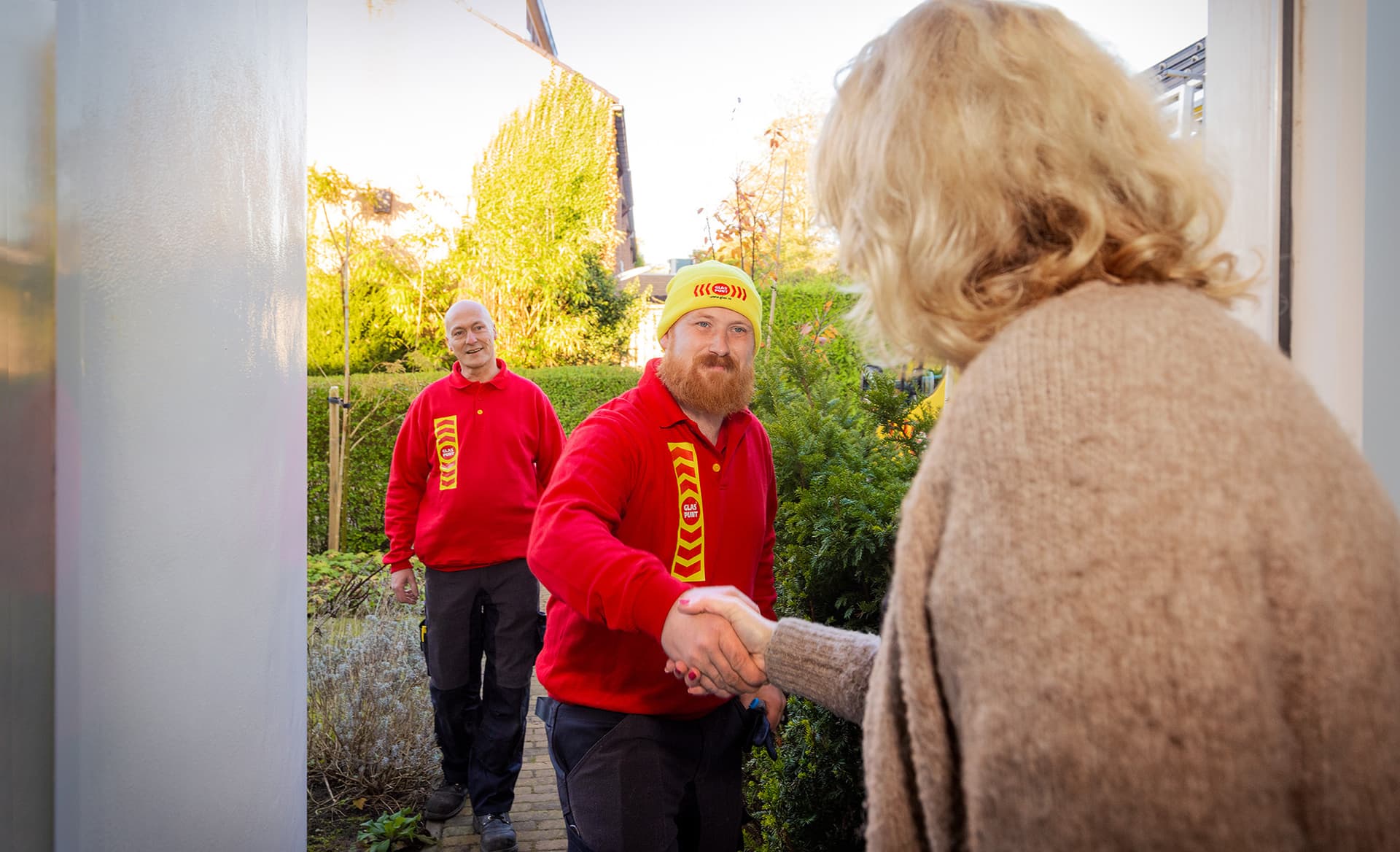 Glaszetter geeft de klant een hand bij aankomst