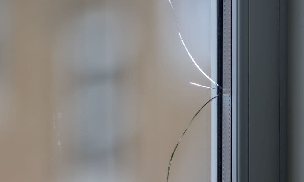 Thermische breuk in dubbel glas met zichtbare scheurvorming langs het raam