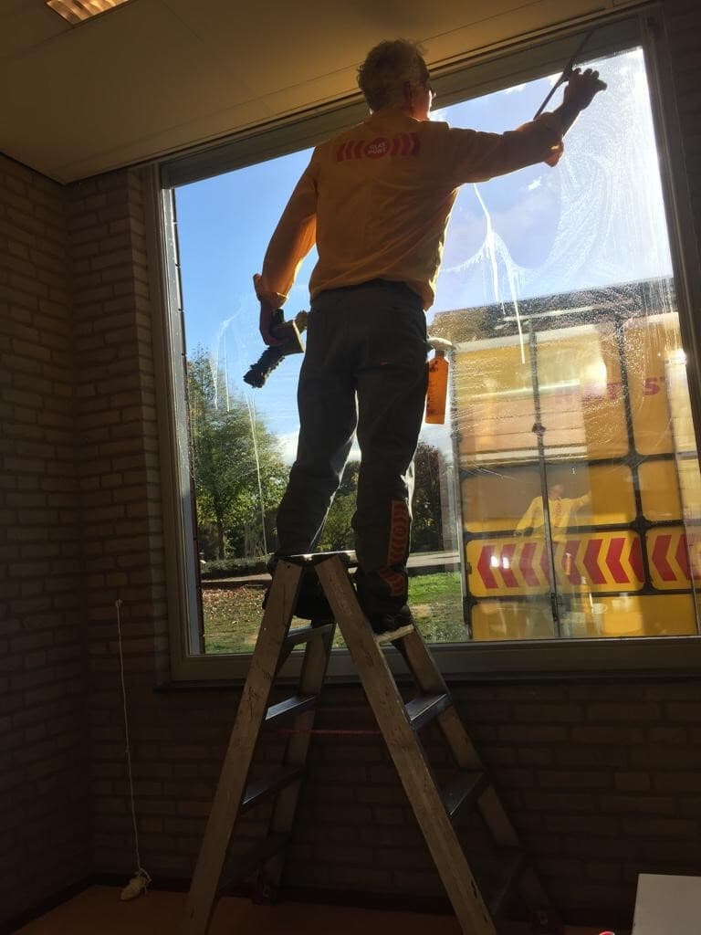 Monteur die een ruit schoonmaakt na vervangen van het glas