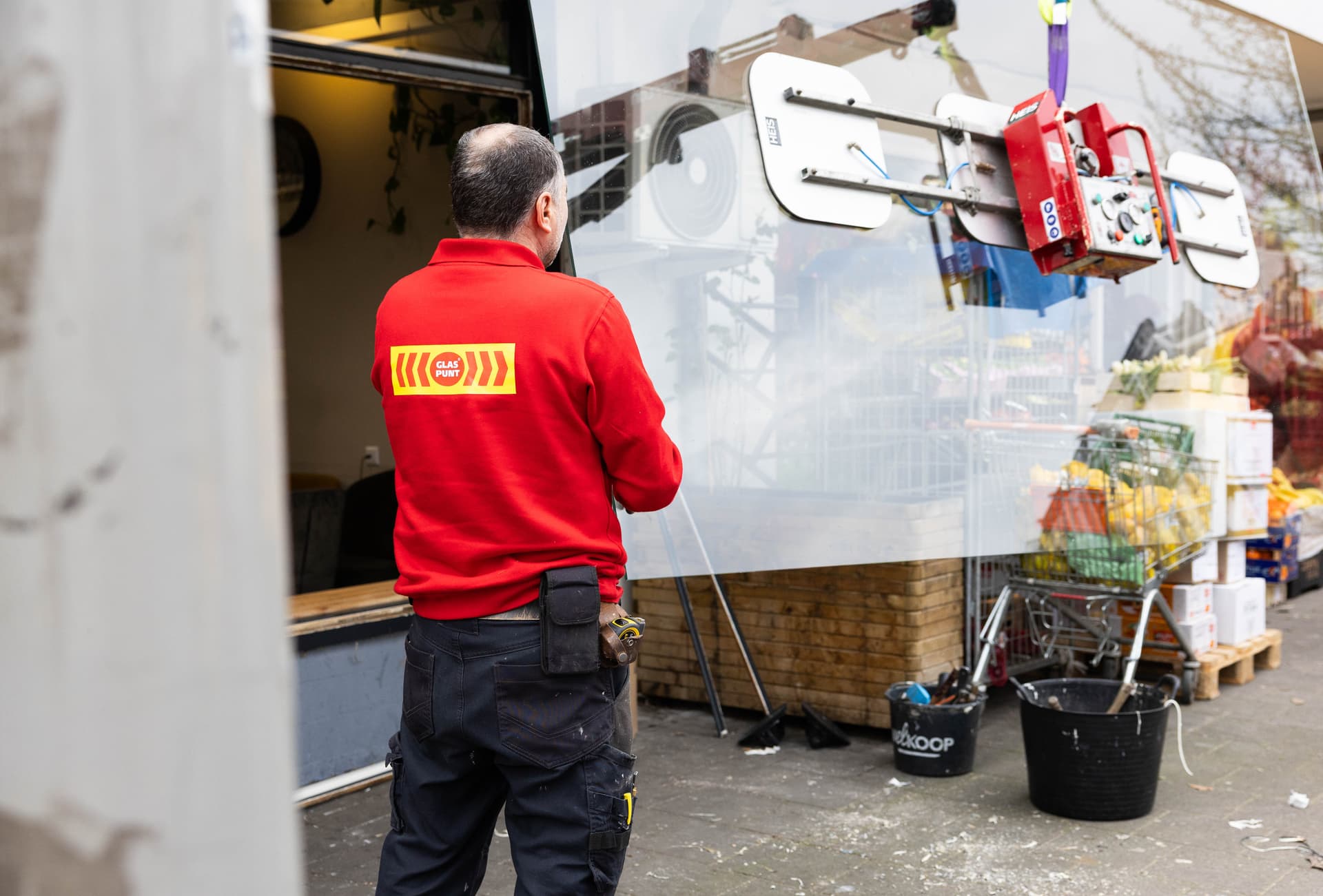 Monteur tillen een ruit met behulp van een kraan