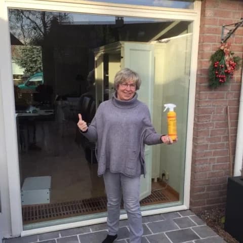 Tevreden klant voor de schuifpui met een Glaspunt glascleaner en duim omhoog