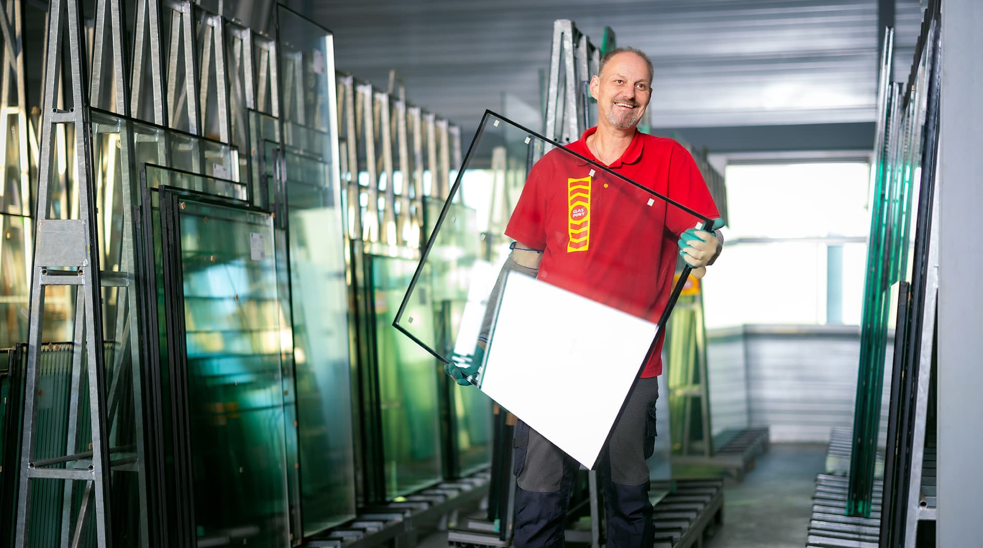 Glaszetter heeft dubbel glas vast en glimlacht